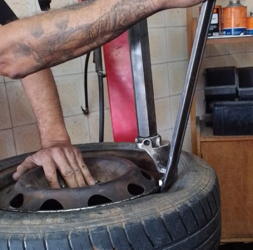 Homem desmontando um pneu